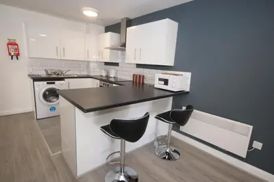 a kitchen with a counter and two stools at Fox Street Delight in Liverpool