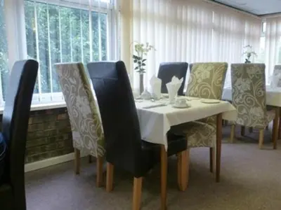 a dining room table and chairs with a white table and a cat on it at The Liver View in Birkenhead