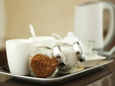 a container of coffee beans on a tray with cups at The Liver View in Birkenhead
