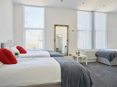 a bedroom with two beds and a mirror at 88 Anfield Road in Liverpool