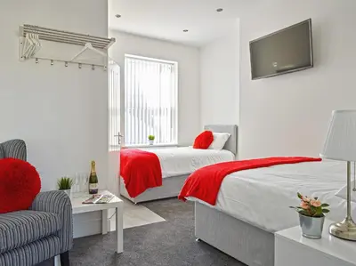 a bedroom with a bed and a tv and a chair at 88 Anfield Road in Liverpool