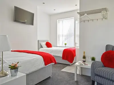 a bedroom with a bed with a red blanket at 88 Anfield Road in Liverpool