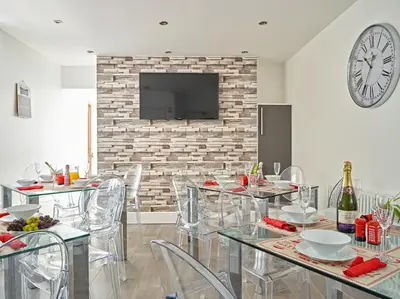 a dining room with tables and chairs and a clock at 88 Anfield Road in Liverpool