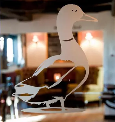 a statue of a duck sitting on a table at The Strawbury Duck Inn in Darwen