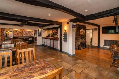 a restaurant with a table and chairs and a bar at The Strawbury Duck Inn in Darwen