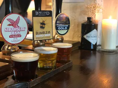 a group of beers on a table with a candle at The Strawbury Duck Inn in Darwen