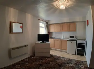 a small kitchen with a tv on a counter at Rosemede Holiday Flats in Blackpool