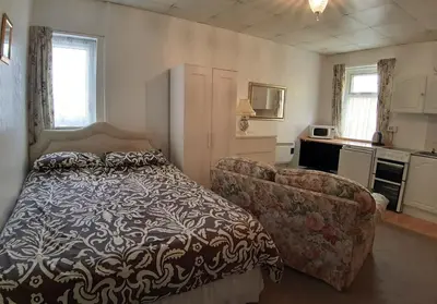 a bedroom with a bed and a couch at Rosemede Holiday Flats in Blackpool