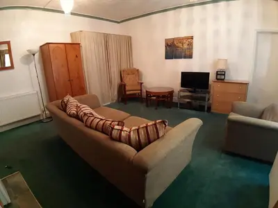 a living room with a couch and a television at Rosemede Holiday Flats in Blackpool