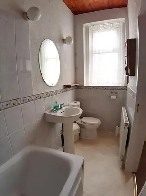 a bathroom with a tub and a sink and a toilet at Rosemede Holiday Flats in Blackpool