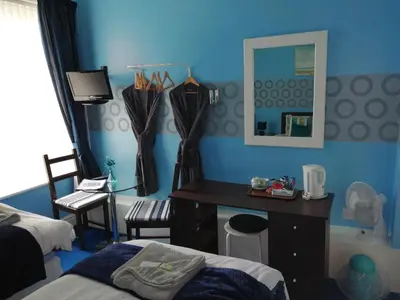 a blue room with a desk and a mirror at The Garnett in Blackpool