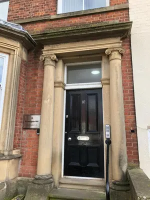 a black door on the side of a brick building at Fishergate ApartHotel 2 - City Centre Location in Preston