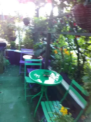 a green table and two chairs in a garden at K.k's North Station Self catering holiday apartments in Blackpool