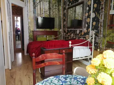 a bedroom with a bed and a desk and a tv at K.k's North Station Self catering holiday apartments in Blackpool
