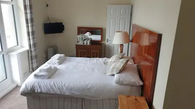 a bedroom with a bed with white sheets and pillows at HOTEL242 in Blackpool