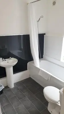 a bathroom with a tub and a sink and a toilet at HOTEL242 in Blackpool