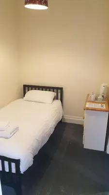 a bedroom with a bed and a night stand with a desk at HOTEL242 in Blackpool
