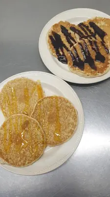 two plates of pancakes with chocolate sauce on them at HOTEL242 in Blackpool