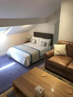 a hotel room with a bed and a couch at The Bowden Lodge Complimentary afternoon tea 15th Mar '26 Terms and Conditions apply in Southport
