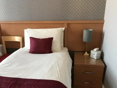 a bed with a red pillow on top of it at The Bowden Lodge Complimentary afternoon tea 15th Mar '26 Terms and Conditions apply in Southport