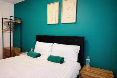 a bedroom with a bed with two green pillows on it at Royal Chambers Liverpool in Liverpool