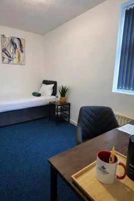 a room with a bed and a table with a coffee mug at Royal Chambers Liverpool in Liverpool