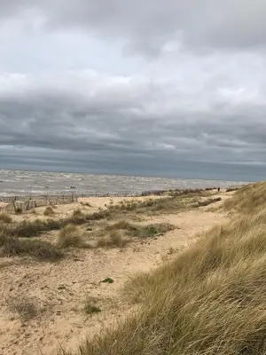 a sandy beach with a fence in the distance at Beach Hideaway in Lytham St Annes