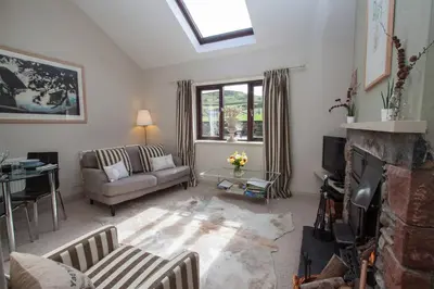a living room with a couch and a fireplace at Tethera at Coal Yeat in Spark Bridge