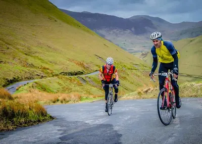 two people riding bikes down a mountain road at Tethera at Coal Yeat in Spark Bridge