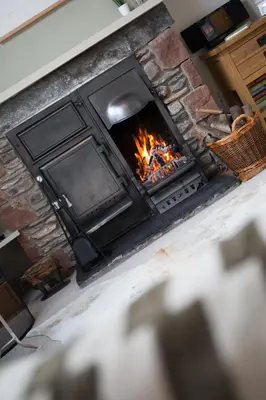 an overhead view of a fireplace with flames in it at Tethera at Coal Yeat in Spark Bridge