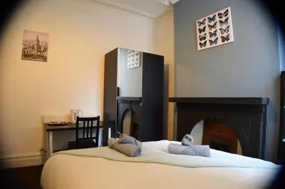 a bedroom with a bed with a fireplace at Old Swan Guest House in Liverpool