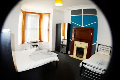 a room with two beds and a fireplace at Old Swan Guest House in Liverpool