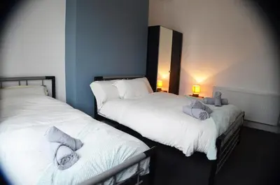 two beds sitting next to each other in a room at Old Swan Guest House in Liverpool
