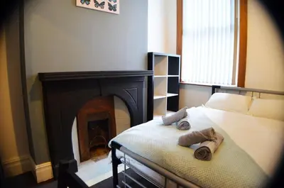 a bedroom with a bed with a fireplace at Old Swan Guest House in Liverpool