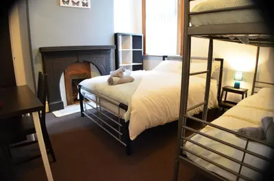 a bedroom with two bunk beds and a fireplace at Old Swan Guest House in Liverpool