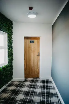 a hallway with a wooden door and a tile floor at Flat Iron Anfield in Liverpool