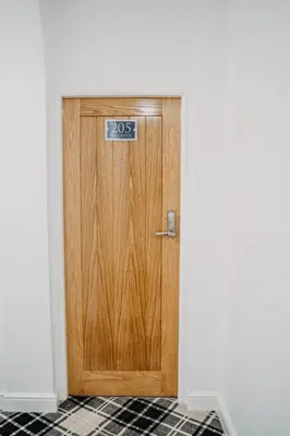 a wooden door with a sign on it in a room at Flat Iron Anfield in Liverpool