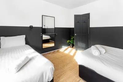 a bedroom with two beds and a mirror at Stanley House - Air Host & Stay - 4 Bedroom in Liverpool