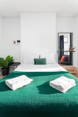 a white bed with green sheets and towels on it at Stanley House - Air Host & Stay - 4 Bedroom in Liverpool