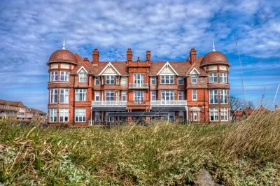 a large brick building with domes on top of a field at The Grand Hotel in Lytham St Annes