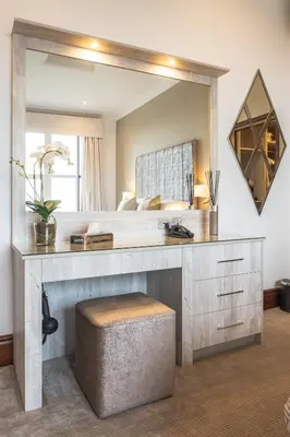 a bedroom with a vanity with a large mirror at The Grand Hotel in Lytham St Annes