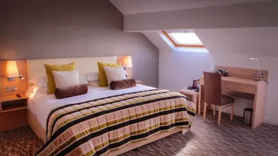 a hotel room with a bed and a desk and a bed sidx sidx sidx sidx at The Grand Hotel in Lytham St Annes