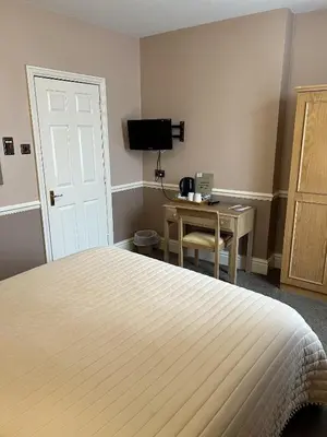 a bedroom with a bed and a desk and a television at Royal Oak Hotel, Garstang in Garstang