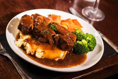 a plate of food with meat and vegetables on a table at Royal Oak Hotel, Garstang in Garstang