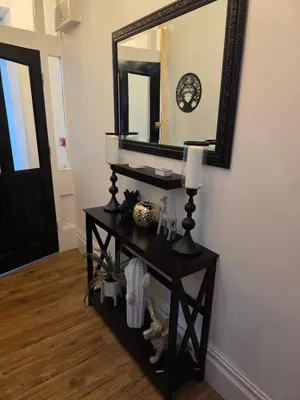 a black console table with a mirror on the wall at Bluebell Hotel in Blackpool