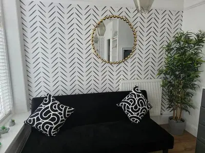 a black couch with two pillows and a mirror at Bluebell Hotel in Blackpool