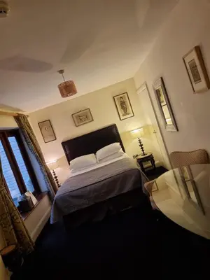 a bedroom with a bed and a table and windows at The Racquet Club in Liverpool