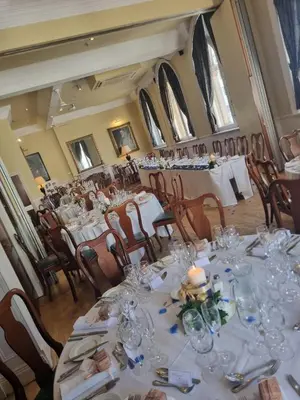 a dining room with tables and chairs with glasses at The Racquet Club in Liverpool