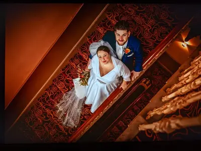 a bride and groom on the stairs at their wedding at The Racquet Club in Liverpool