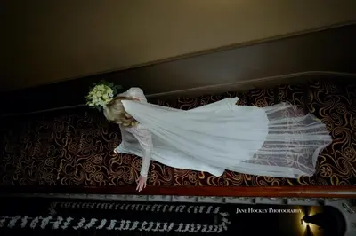 a woman in a wedding dress sitting on a piano at The Racquet Club in Liverpool